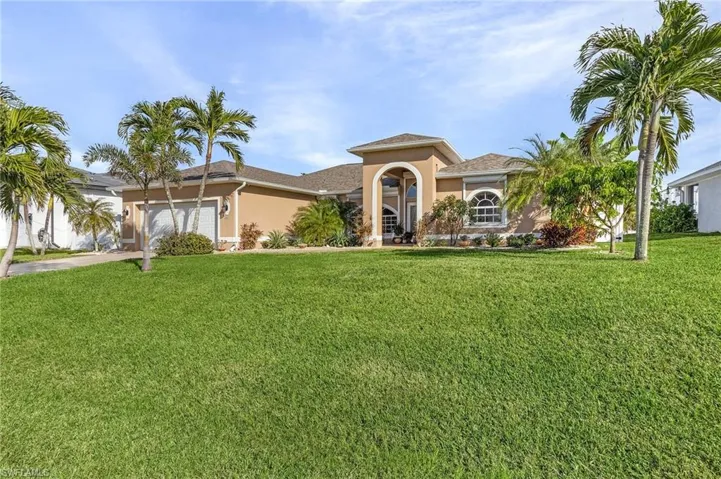 View of front of home with a garage and a front lawn