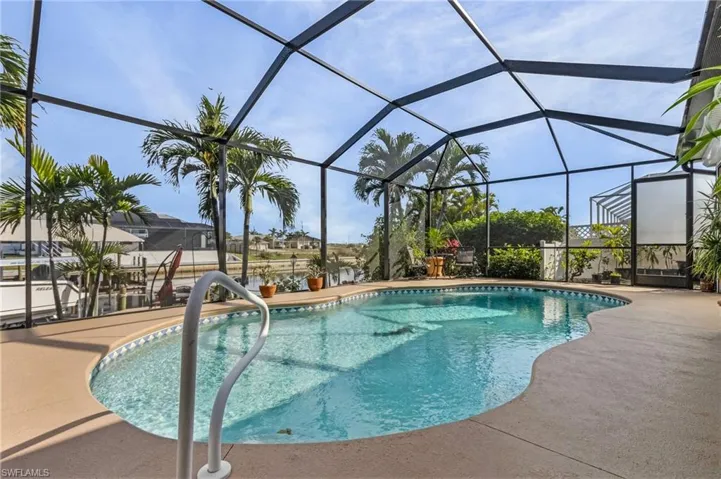 View of pool featuring glass enclosure and a patio area