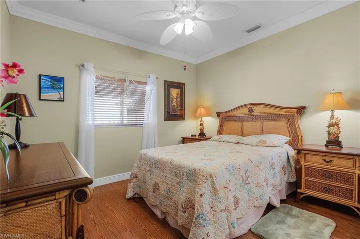 Bedroom featuring hardwood / wood-style floors, ceiling fan, and crown molding