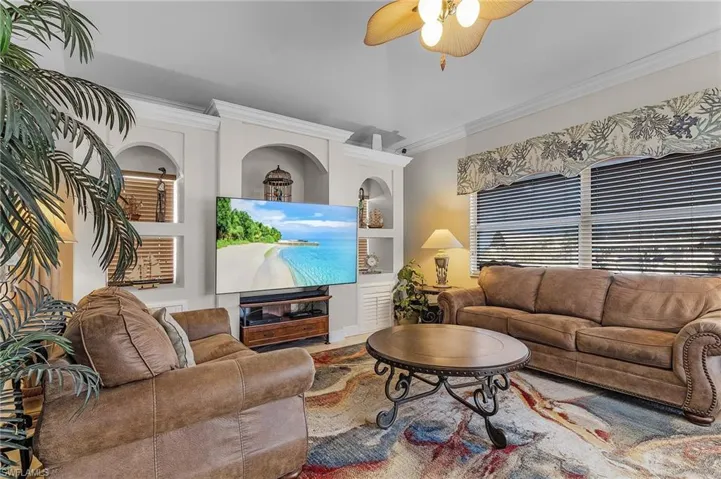 Living room with ceiling fan and crown molding