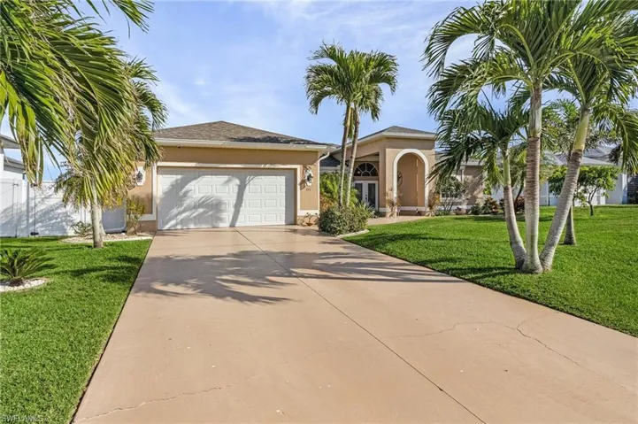 View of front of property with a front yard and a garage