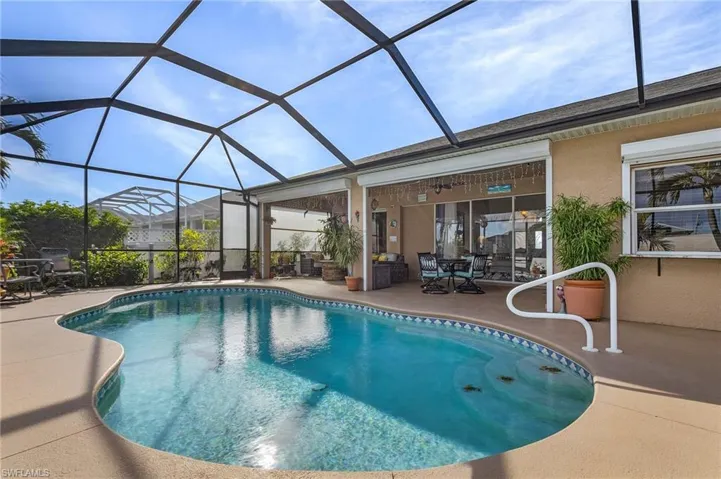 View of swimming pool featuring glass enclosure and a patio