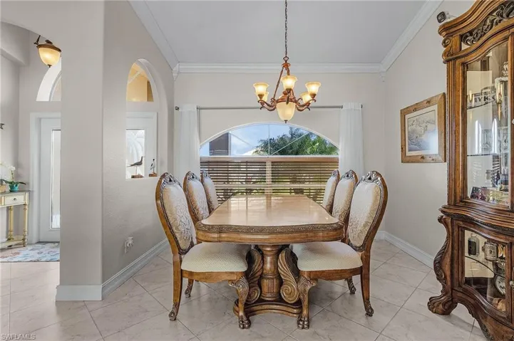 Dining room featuring crown molding and an inviting chandelier