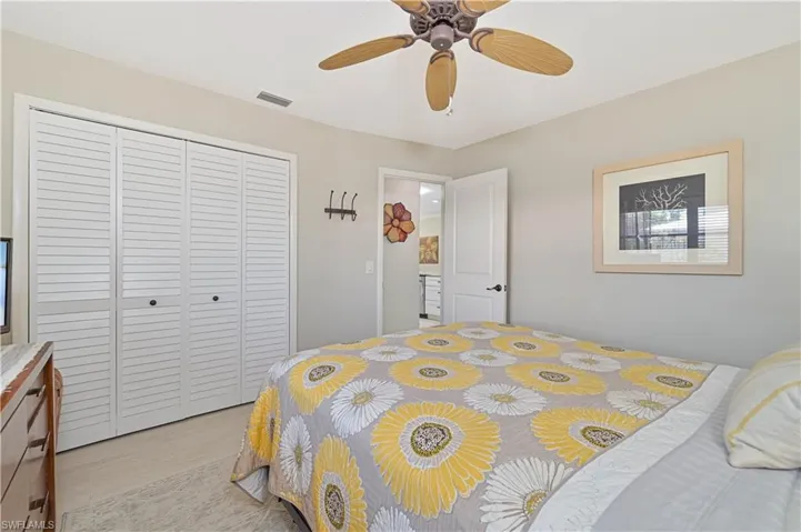 This room features a ceiling fan, a closet with louvered bi-fold doors, and light-colored walls