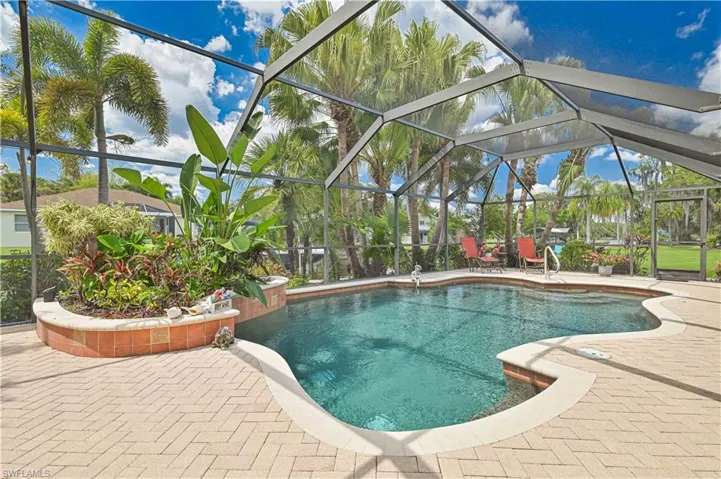 The property features a screened-in swimming pool with a paved patio area