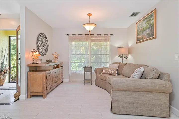This room features light-colored tile flooring, a window providing natural light, and a ceiling-mounted light fixture