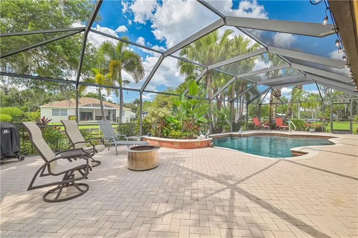 Outdoor living area with a screen enclosure, a swimming pool, and a brick paver patio