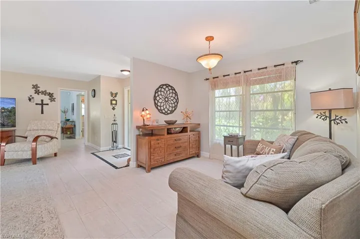 Living area featuring light-toned flooring, a window providing natural light, and a ceiling light fixture