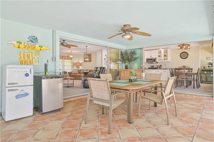 The property offers an expansive covered patio area with tiled flooring and a ceiling fan, providing comfortable outdoor living