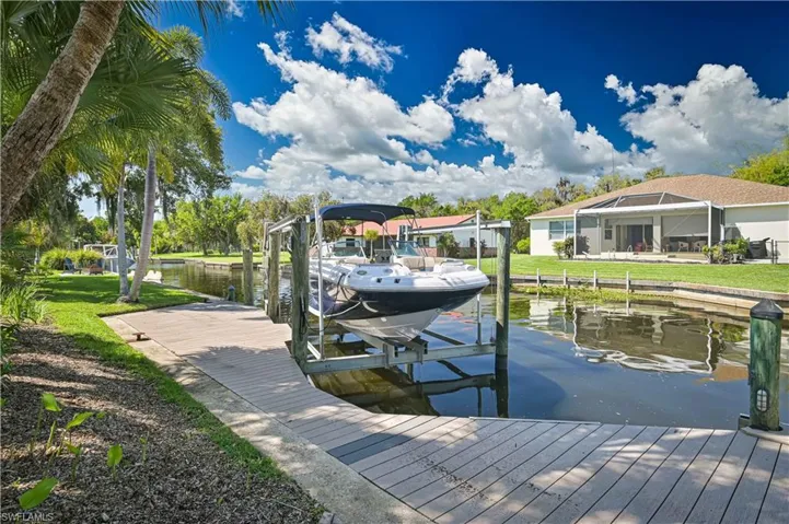 The property features a private boat lift and dock, offering direct access to the canal