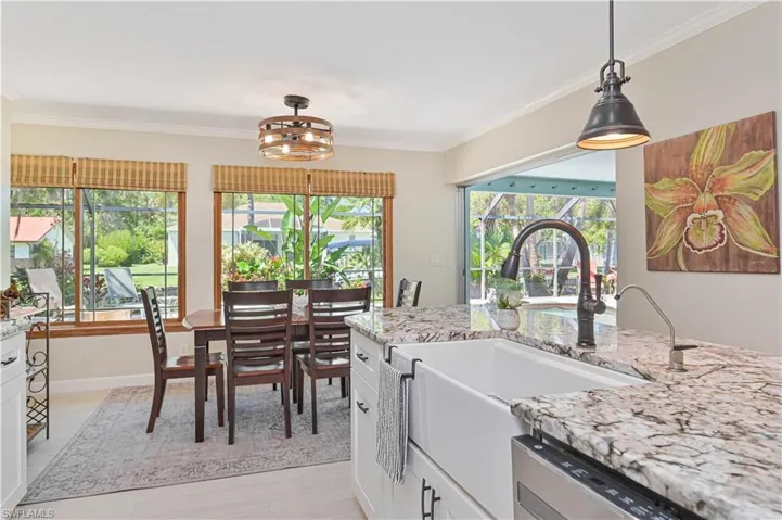 The kitchen features a farmhouse sink, granite countertops, and a dark bronze faucet