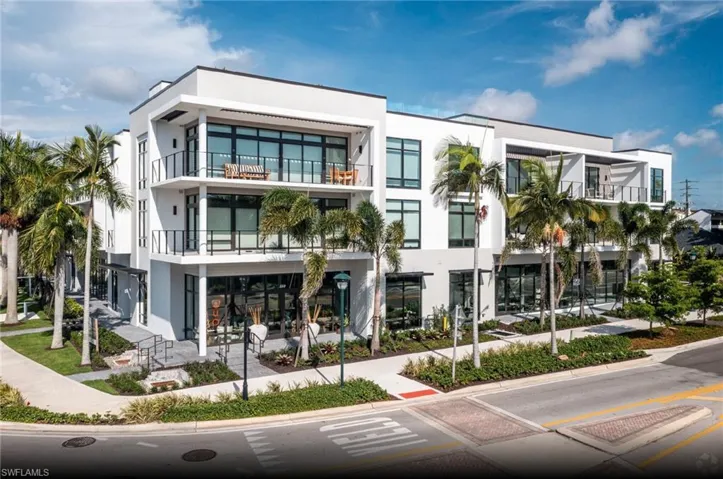Modern multi-story building featuring expansive balconies with glass railings