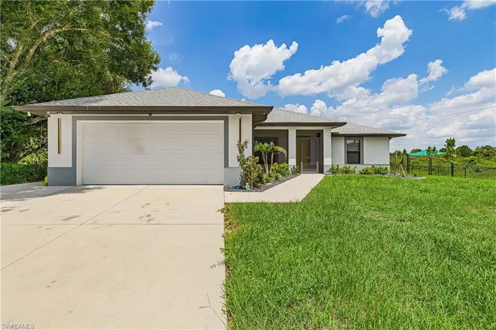 Contemporary exterior with a covered entry, attached garage, and a concrete driveway