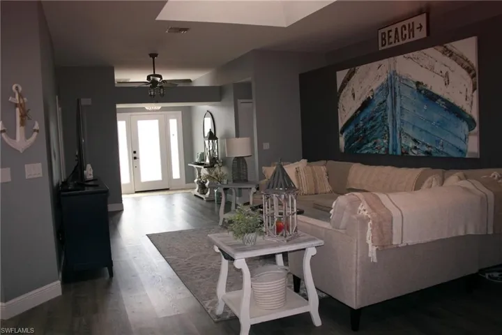 Wood-finish flooring throughout, transom window over the front entry door, skylight, and recessed ceiling fan