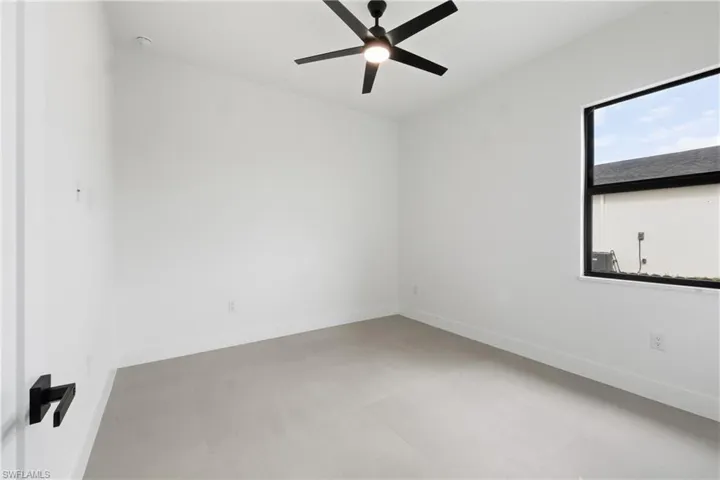 Unfurnished room with concrete flooring and ceiling fan