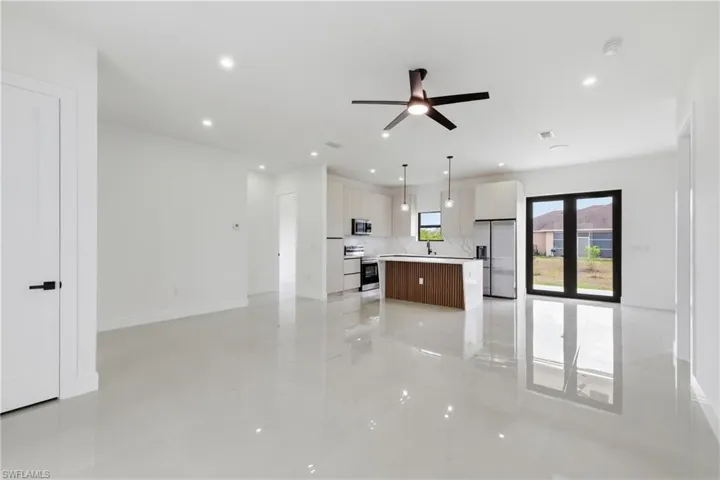 Unfurnished living room with ceiling fan and recessed lighting