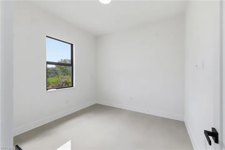 Spare room with baseboards and concrete floors