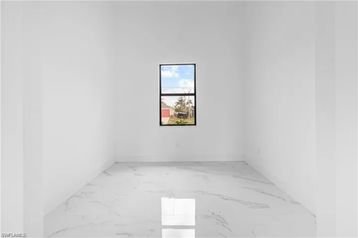 Spare room with light marble finish floors and baseboards