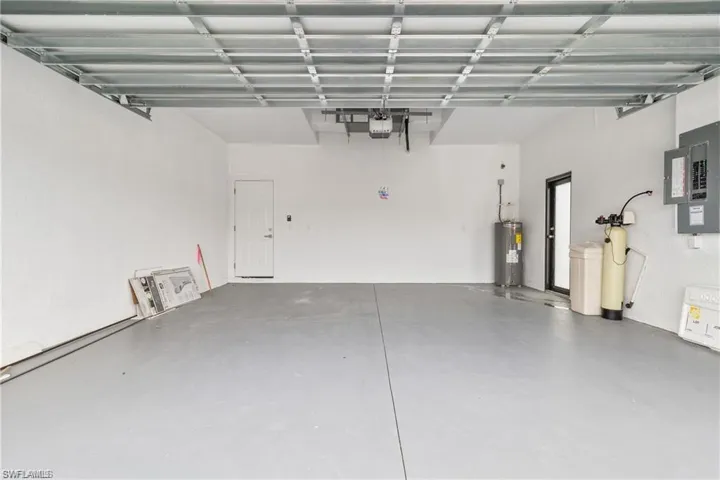 Garage featuring electric panel and electric water heater
