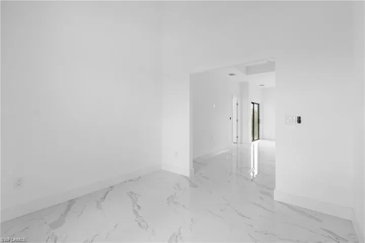 Empty room featuring baseboards and light marble finish floors
