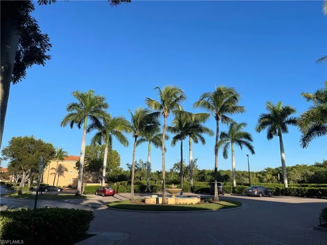 A welcoming tropical paradise entrance, framed by lush palm trees and basking in the warm, sunny embrace of Southwest Florida.