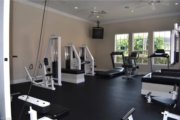 Workout area featuring a ceiling fan, baseboards, crown molding, and recessed lighting