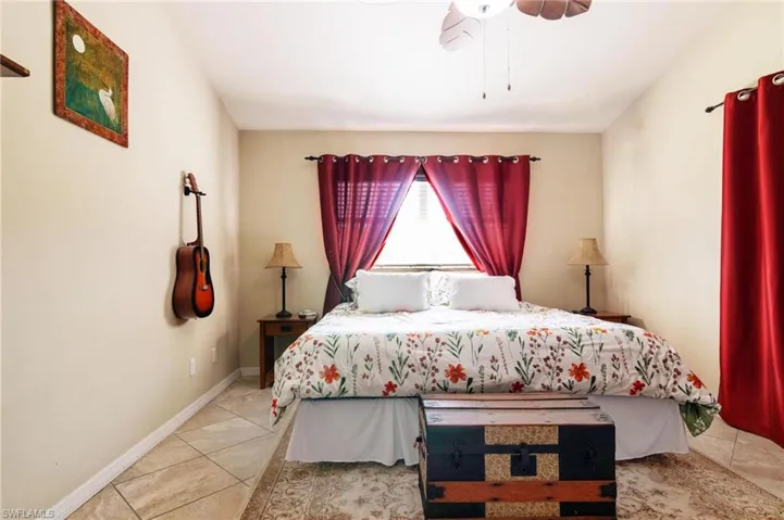 Tiled bedroom featuring baseboards and ceiling fan
