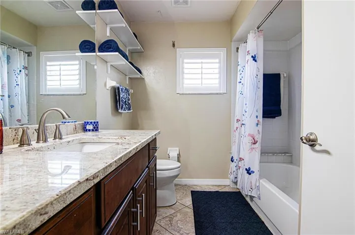 Full bath featuring vanity, tile patterned floors, and shower / bathtub combination with curtain