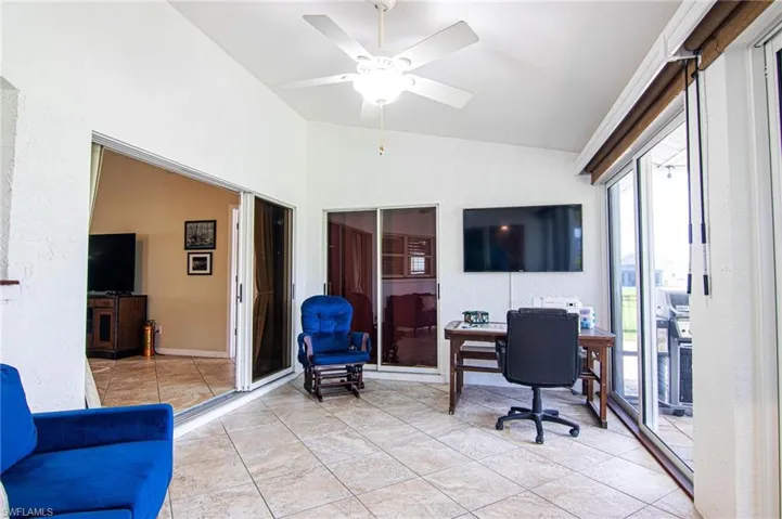 Office area featuring vaulted ceiling, a ceiling fan, and light tile patterned floors