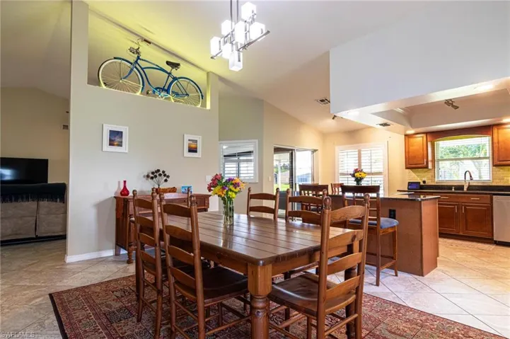Dining area featuring light tile patterned floors and high vaulted ceiling