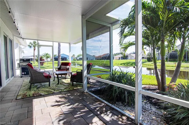 Sunroom with a water view and a residential view