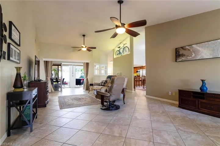 Living room with ceiling fan and high vaulted ceiling