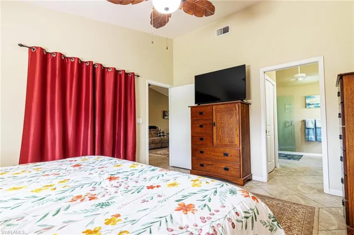 Bedroom featuring a high ceiling, light tile patterned flooring, and a ceiling fan