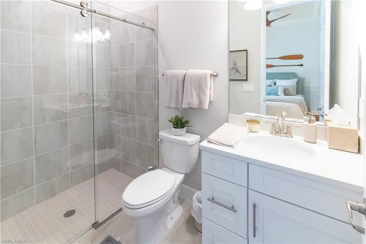 Bathroom featuring vanity, a shower with shower door, and toilet