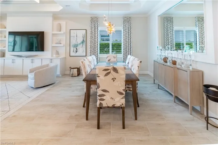 Dining space featuring an inviting chandelier, a tray ceiling, and ornamental molding