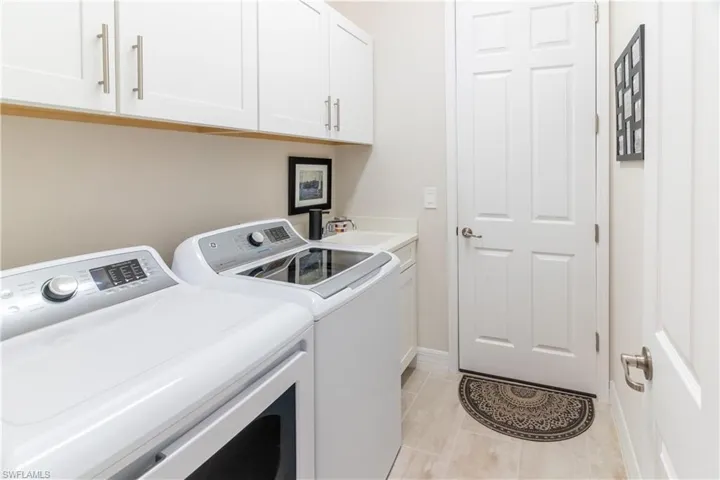 Laundry area featuring cabinets, sink, and washer and dryer