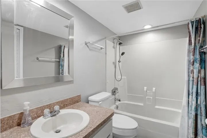 Full bathroom with shower / bath combo with shower curtain and vanity