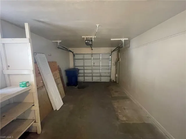 Garage featuring a garage door opener and baseboards