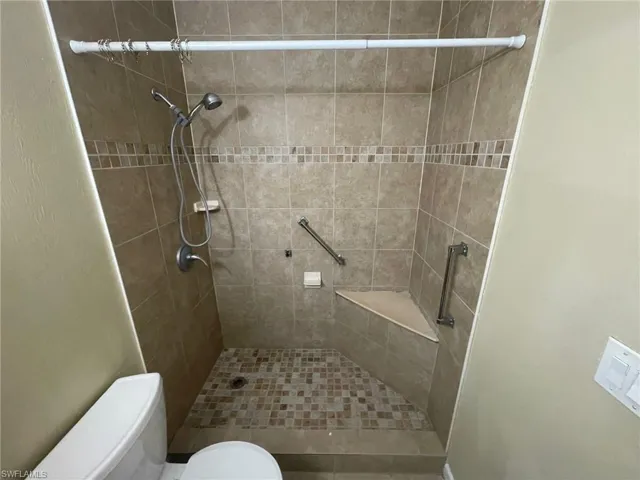 Full bathroom featuring toilet and a shower stall