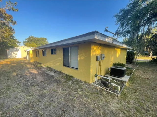 View of side of home featuring central AC unit and stucco siding