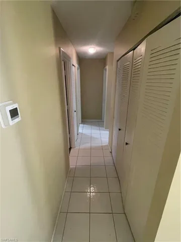 Hallway featuring light tile patterned floors and baseboards