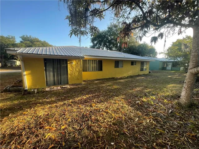 Back of property with stucco siding and metal roof