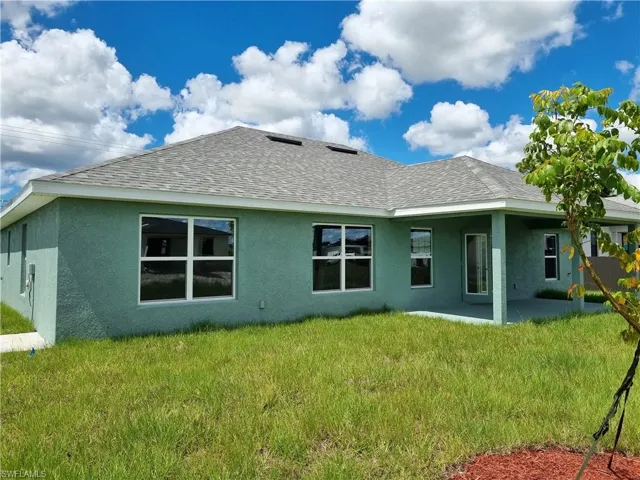 Rear view of house with a lawn and a patio area