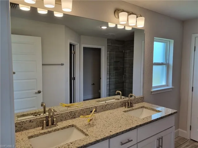 Bathroom featuring hardwood / wood-style floors, vanity, toilet, and a shower with shower door