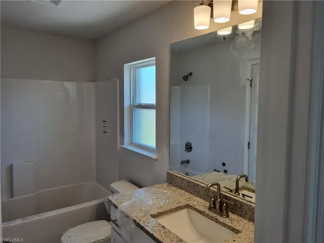 Full bathroom featuring shower / bath combination, toilet, and vanity
