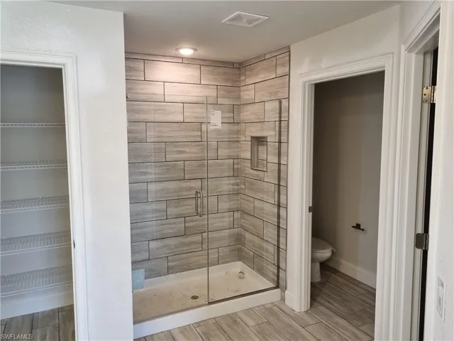 Bathroom with a shower with shower door and toilet
