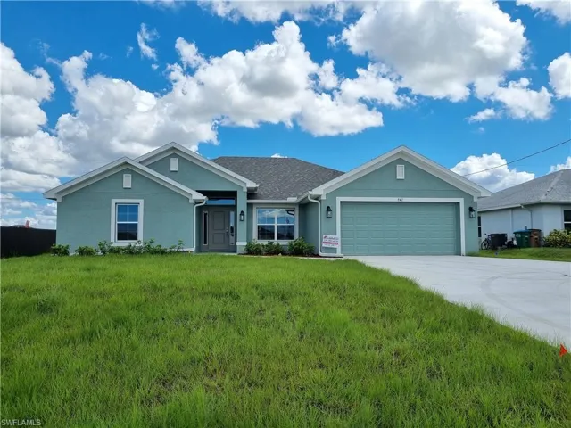View of front of property featuring a garage and a front lawn