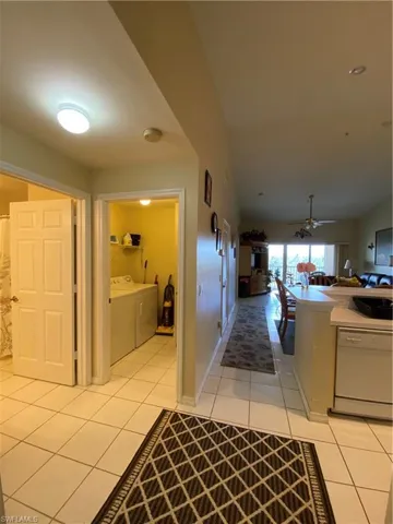 Corridor with light tile patterned floors and washer and dryer