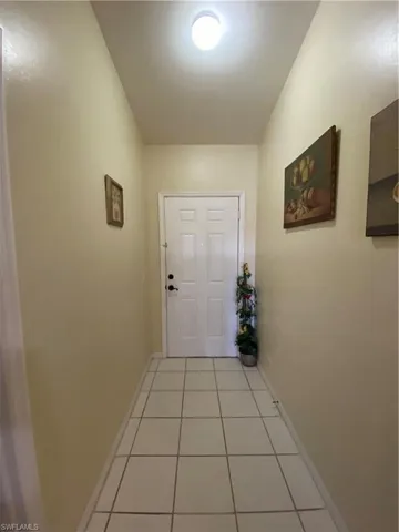 Doorway to outside with tile patterned floors and baseboards