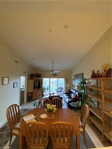 Dining room featuring lofted ceiling, light tile patterned floors, and ceiling fan